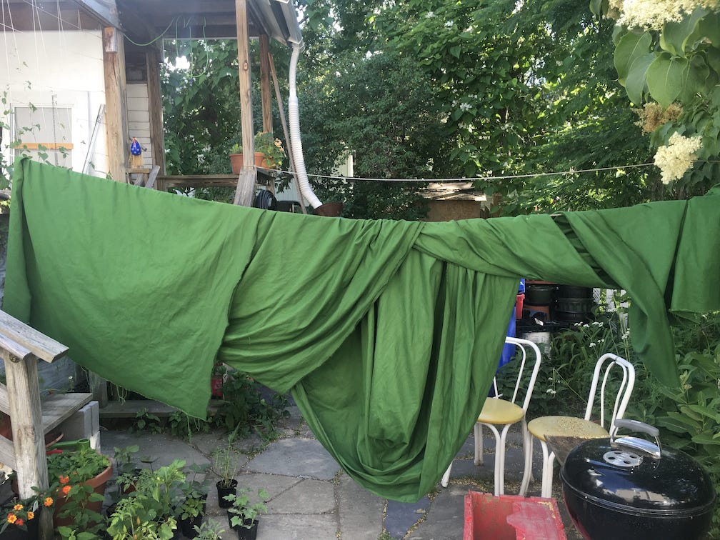 a large swath of green fabric hanging on a clothesline