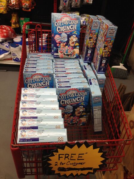 a cart full of Cotton Candy Crunch cereal with a sign that reads '"FREE" 2 per customer'