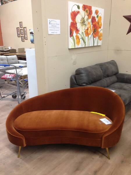 a swoopy, orange chaise lounge chair